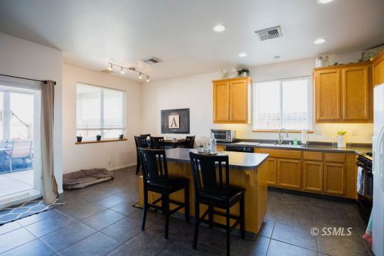 812 South Nevada Street Ridgecrest, CA 93555 - Photo 9 of 34 a kitchen with stainless steel appliances granite countertop table chairs sink and window