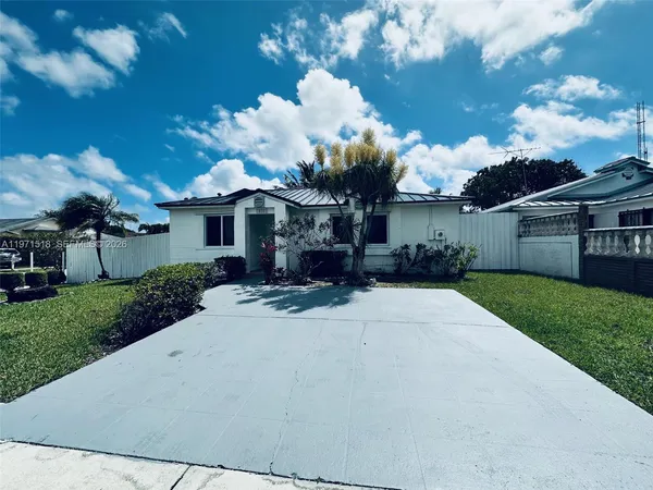 a front view of a house with a yard and a garden