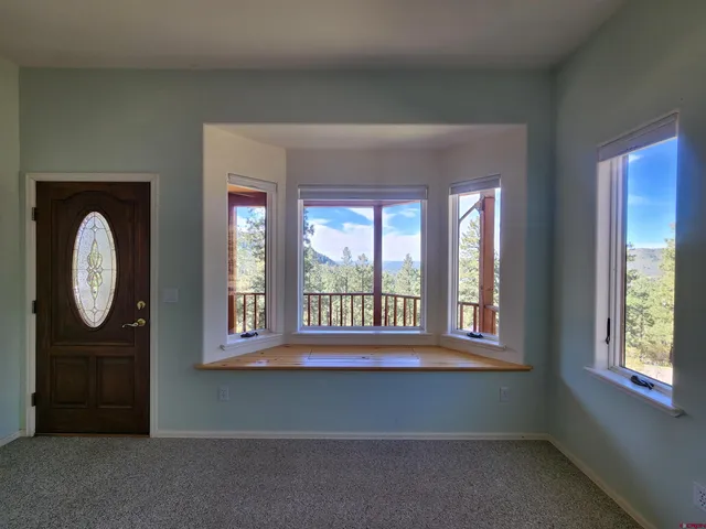 a living room with a large window and a bed
