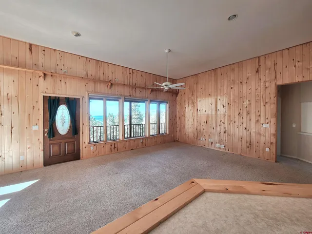 a view of an empty room with kitchen and a window