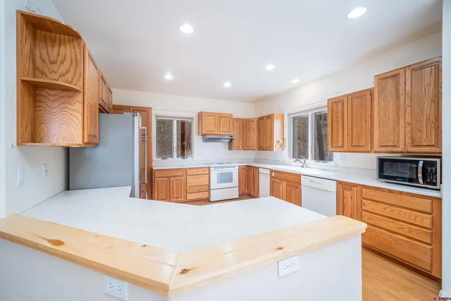 a kitchen with stainless steel appliances a refrigerator sink and wooden cabinets