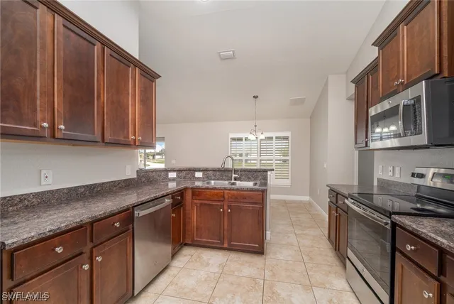 a kitchen with kitchen island granite countertop a sink dishwasher stove and cabinets