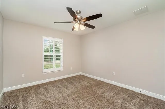 a bathroom with a granite countertop sink a large mirror a toilet and a window