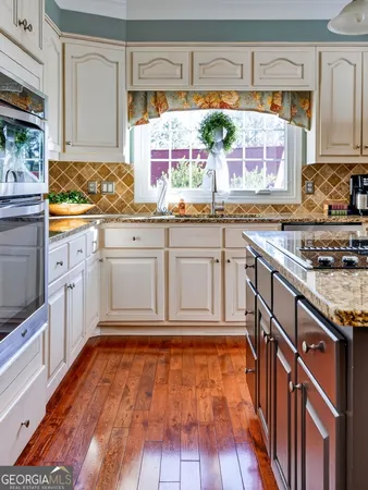 a kitchen with granite countertop white cabinets and white appliances