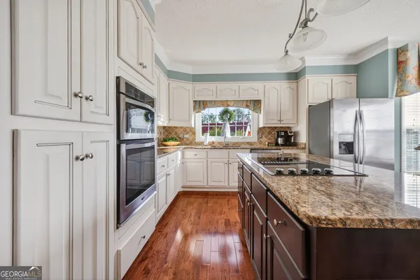 a dining room with furniture a chandelier and kitchen view