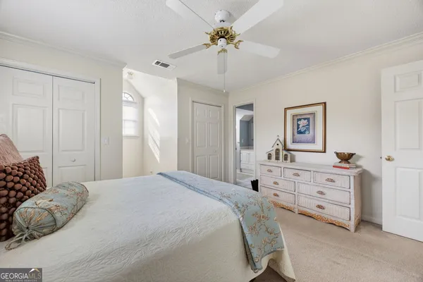 a bedroom with a bed table and a book shelf