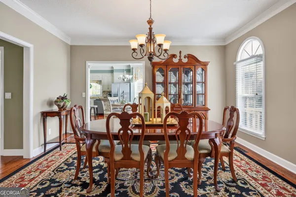 a view of a dining room with furniture wooden floor and chandelier
