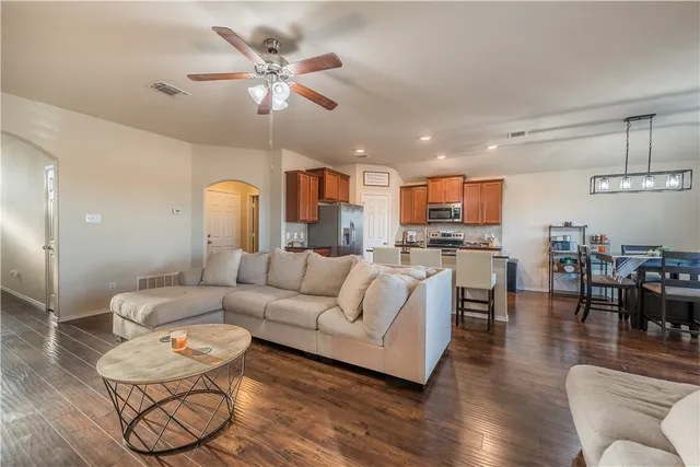 a living room with furniture kitchen view and a chandelier
