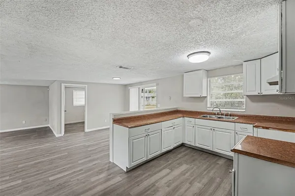 a kitchen with a sink cabinets and wooden floor