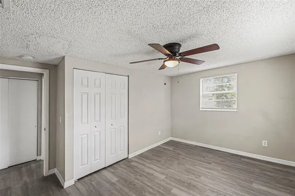 a view of a room with wooden floor and a ceiling fan