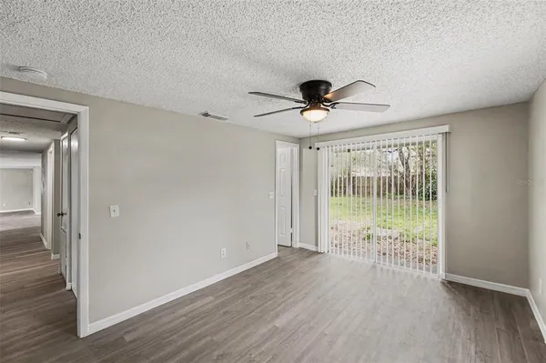 a view of an empty room with wooden floor and a large window