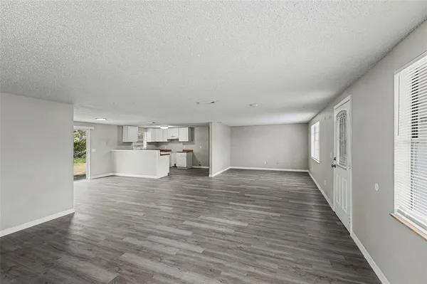 a view of a kitchen with wooden floor and a window