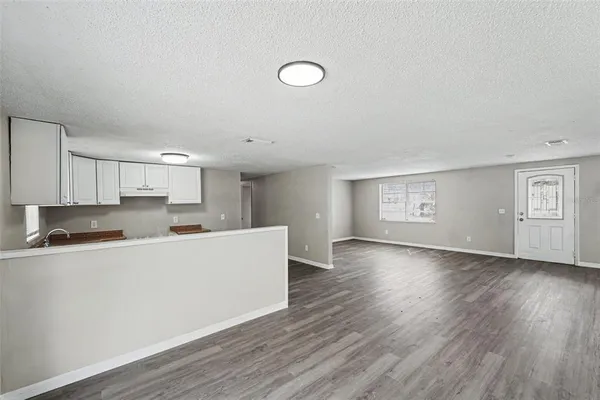 a view of a kitchen with wooden floor and electronic appliances