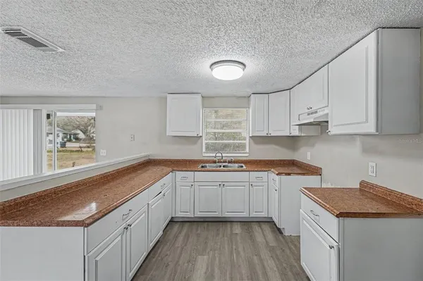 a kitchen with a sink stove and cabinets