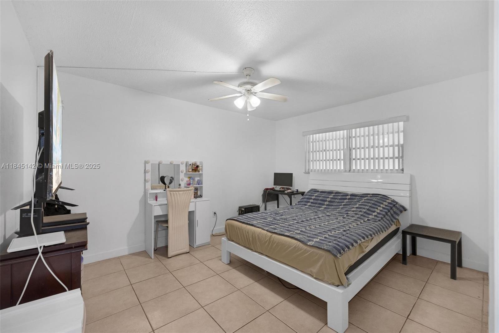 8500 Southwest 109th Avenue, Unit 6112 Miami, FL 33173 - Photo 24 of 52 a spacious bedroom with a bed and a chandelier