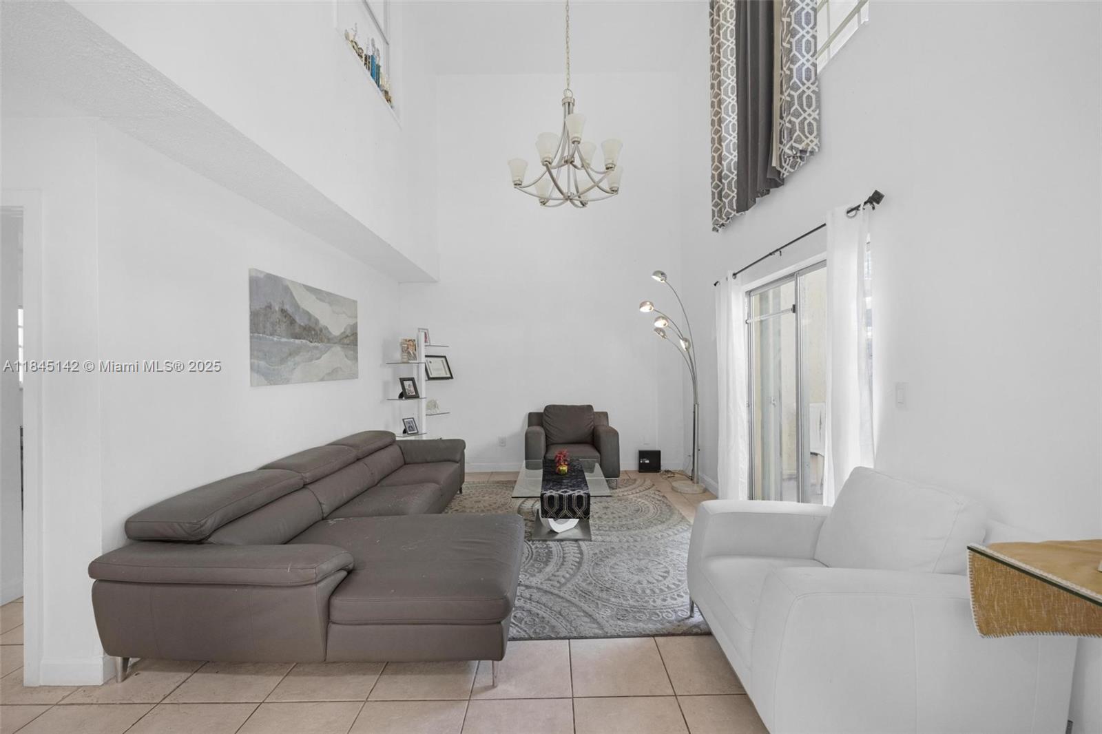 8500 Southwest 109th Avenue, Unit 6112 Miami, FL 33173 - Photo 5 of 52 a living room with furniture and a chandelier