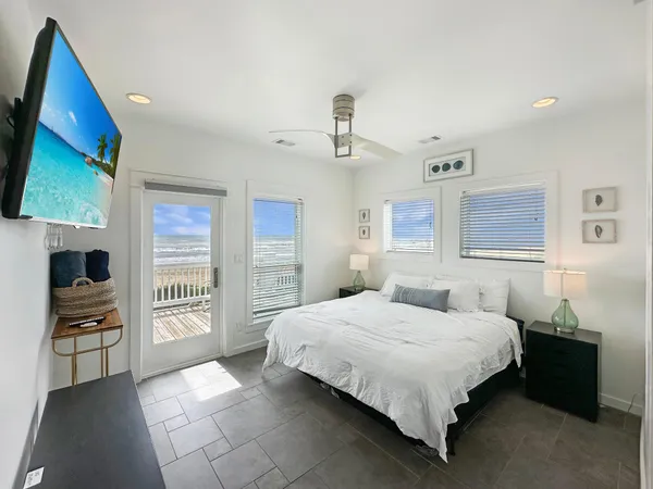 a bedroom with a bed and a flat tv screen on the dresser