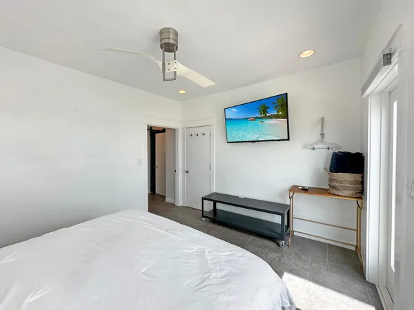 a bedroom with bed and a painting on the wall