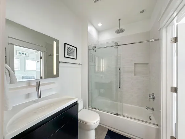 a bathroom with a sink a toilet and shower