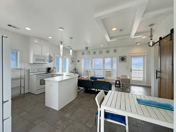 a large kitchen with kitchen island a sink a stove a dining table and chairs