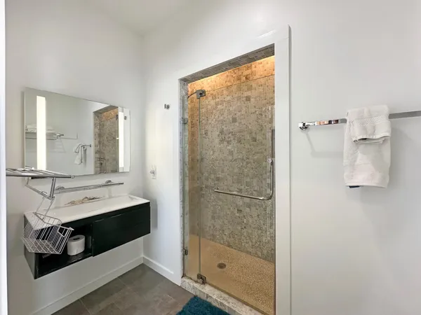a bathroom with a shower sink and mirror