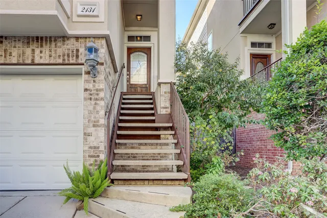 a view of a house with a yard and potted plants