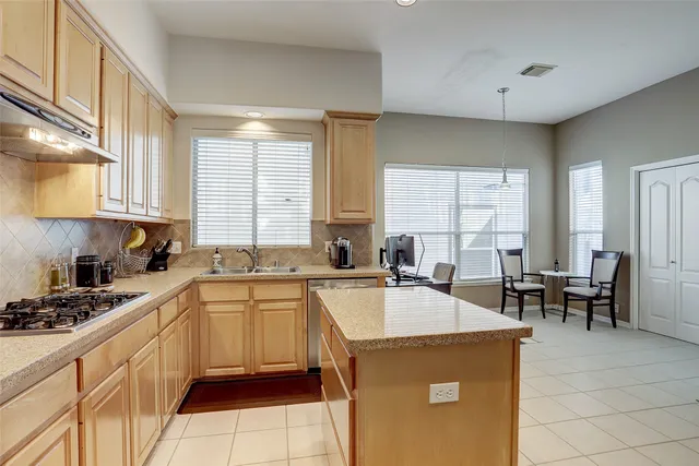 a kitchen with a stove a sink a dining table and chairs