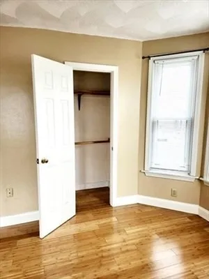 a view of a room with wooden floor and a window