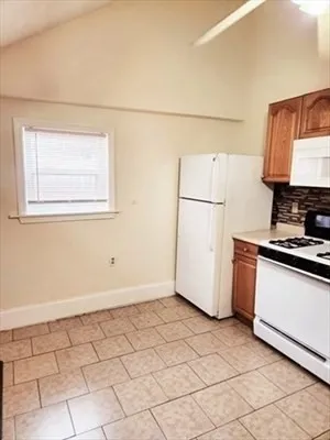 a kitchen with a sink a stove and white cabinets