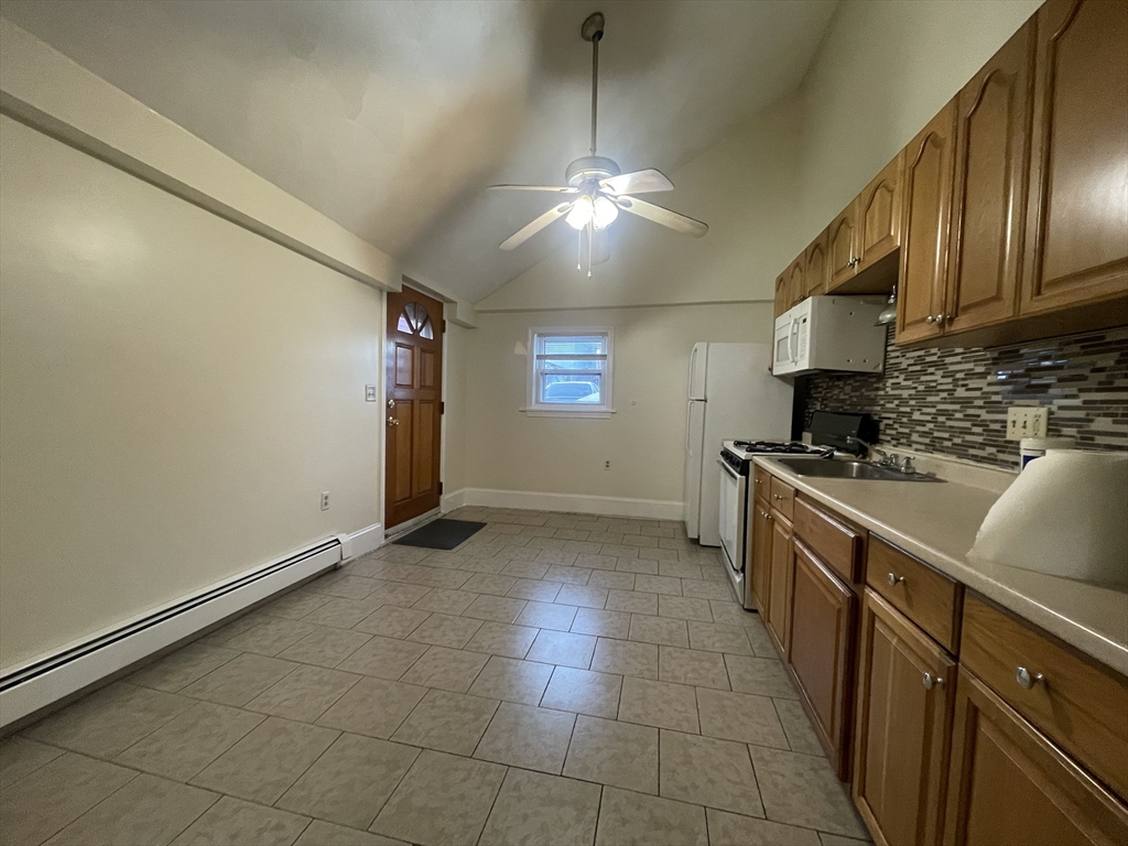 66 Pearl Street, Unit 1 Chelsea, MA 02150 - Photo 10 of 10 a kitchen with stainless steel appliances granite countertop a sink a stove top oven a counter space and cabinets