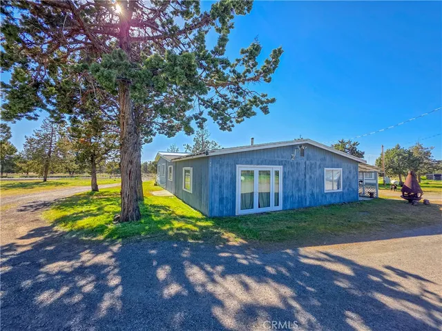 a view of a yard in front of a house with large tree