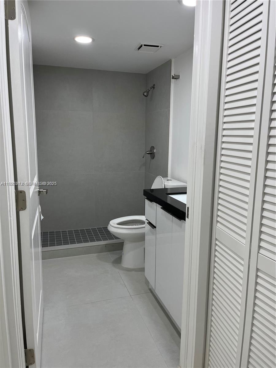 9917 West Okeechobee Road, Unit 203 Hialeah, FL 33016 - Photo 7 of 10 a bathroom with a granite countertop toilet and a sink