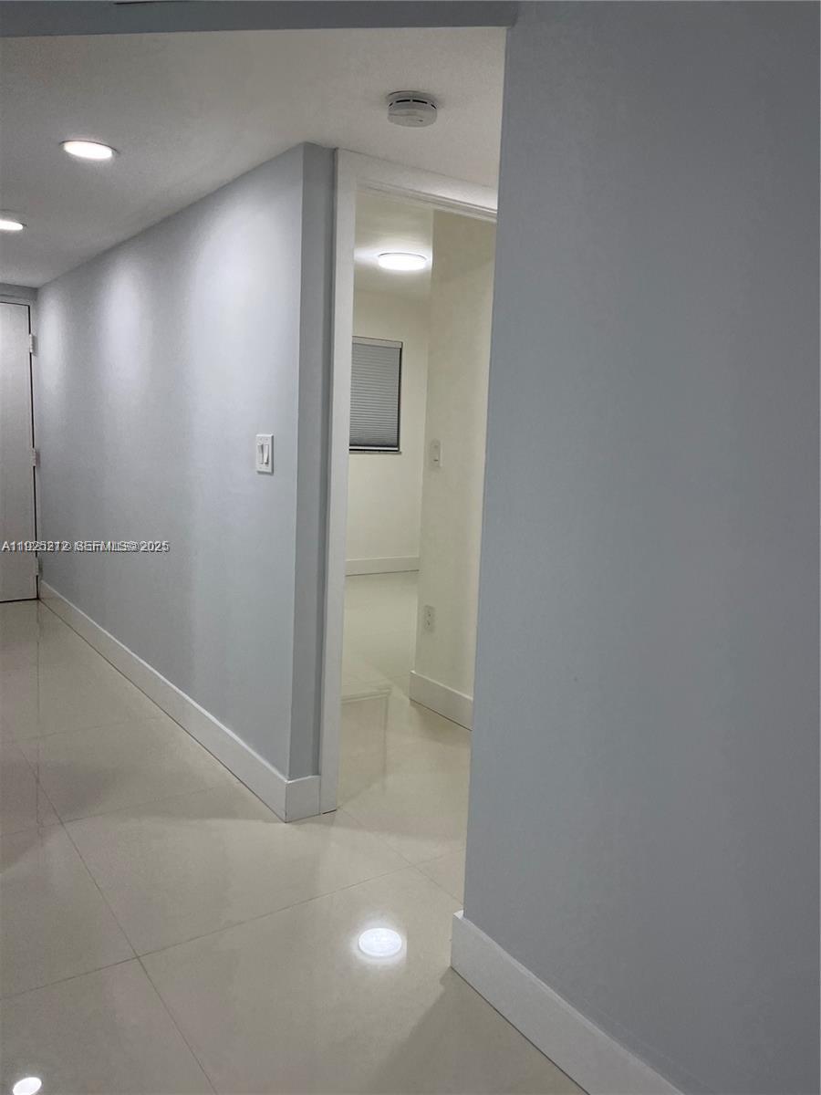 9917 West Okeechobee Road, Unit 203 Hialeah, FL 33016 - Photo 10 of 10 an empty room with mirror and a bathroom