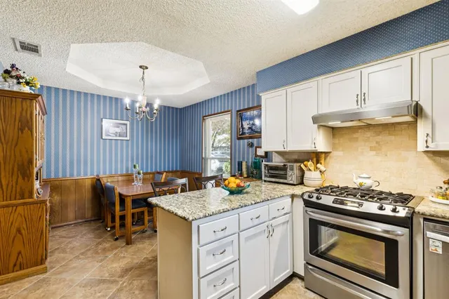 a kitchen with granite countertop cabinets stainless steel appliances and a counter space