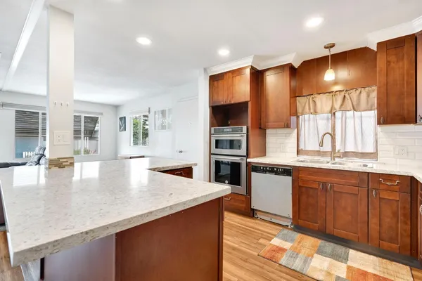 a kitchen with granite countertop a sink stove and cabinets