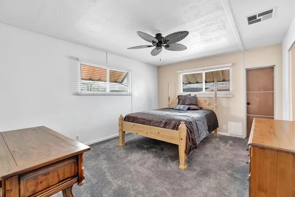 a bed room with a bed and a ceiling fan