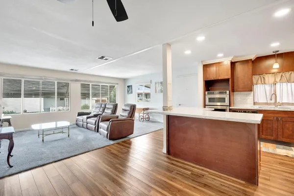 a large kitchen with granite countertop a large counter top sink and stainless steel appliances