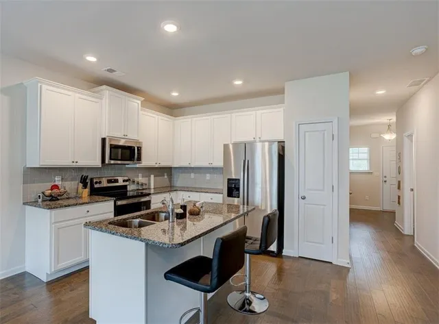 a kitchen with stainless steel appliances a stove a sink a refrigerator and cabinets