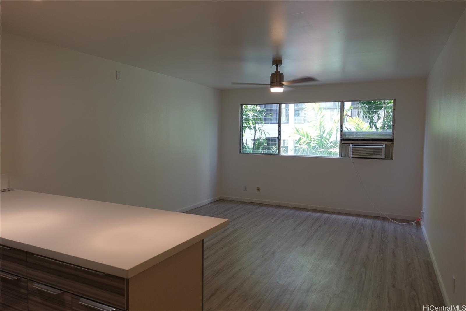 350 Aoloa Street, Unit A111 Kailua, HI 96734 - Photo 7 of 24 an empty room with wooden floor chandelier and windows