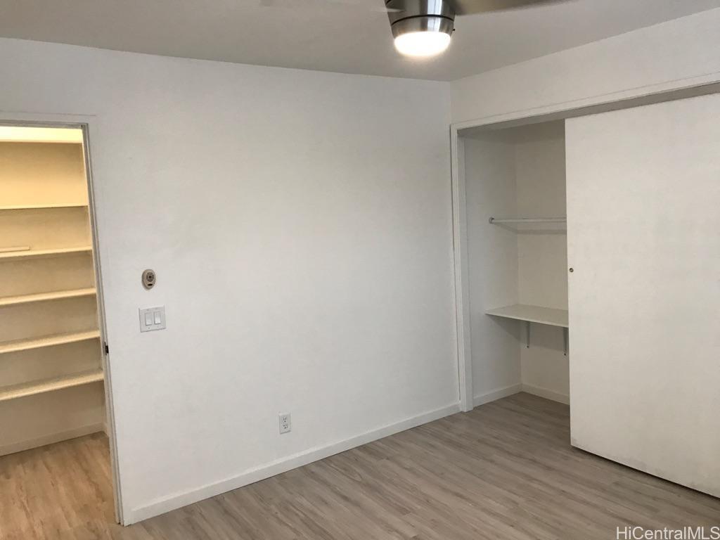 350 Aoloa Street, Unit A111 Kailua, HI 96734 - Photo 9 of 24 a view of an empty room with wooden floor and a window