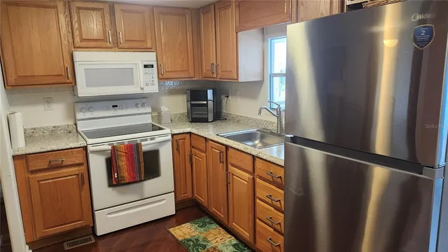 a kitchen with stainless steel appliances granite countertop a refrigerator and a stove top oven
