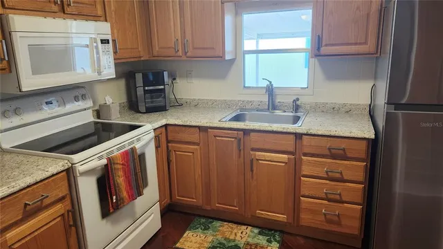 a kitchen with stainless steel appliances granite countertop a sink stove and cabinets