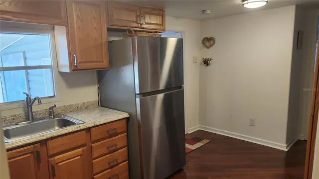 a kitchen with stainless steel appliances granite countertop a refrigerator and a sink