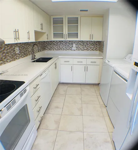 a kitchen with a sink a stove and cabinets
