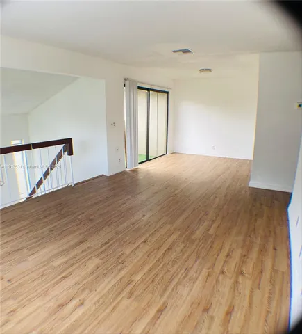 a view of an empty room and wooden floor