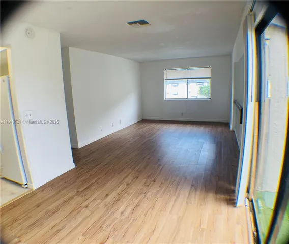a view of an empty room and wooden floor