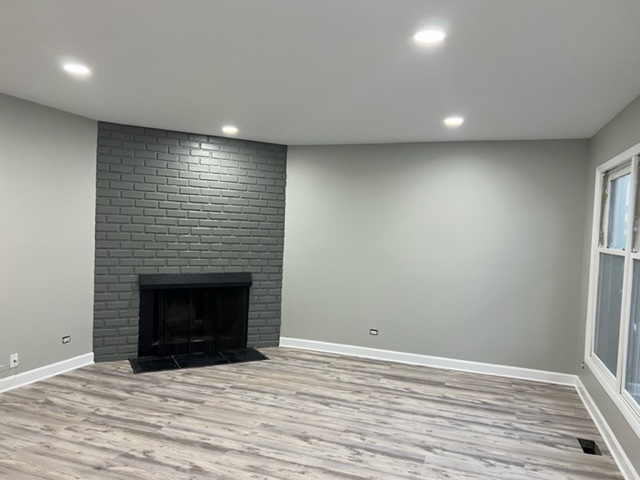 1010 Denham Place Schaumburg, IL 60169 - Photo 3 of 16 a view of an empty room with wooden floor and a fireplace