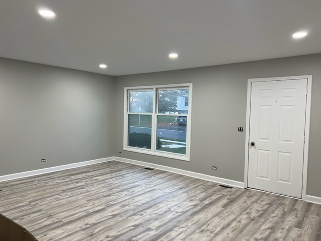 1010 Denham Place Schaumburg, IL 60169 - Photo 4 of 16 a view of an empty room with wooden floor and a window