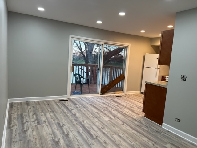 1010 Denham Place Schaumburg, IL 60169 - Photo 7 of 16 a view of an empty room with wooden floor and a window