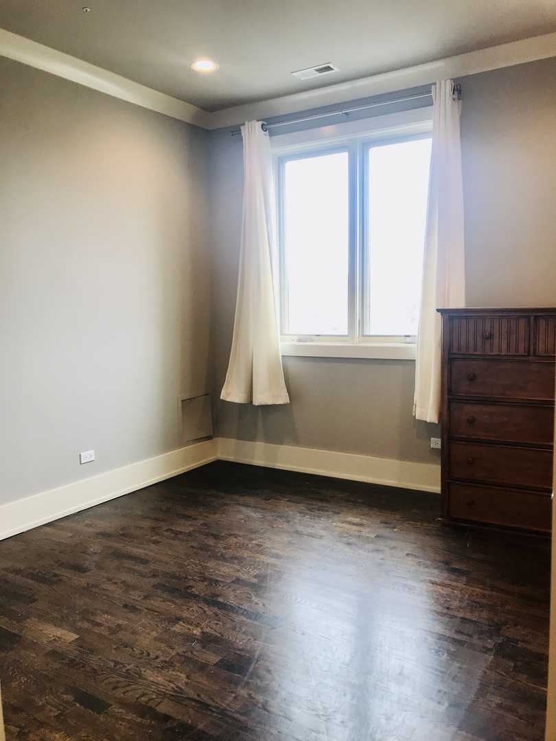 4029 South Ellis Avenue, Unit 5S Chicago, IL 60653 - Photo 27 of 31 wooden floor in an empty room with a window